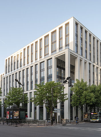 Large office complex with a columned facade along a main urban road