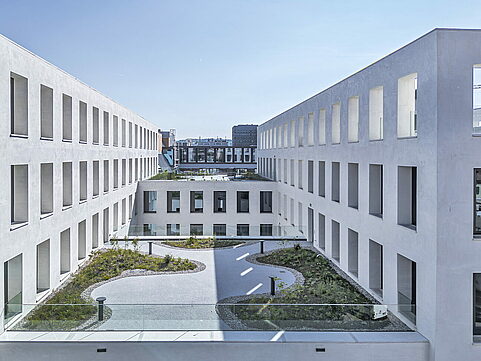 Rooftop terrace with curving paths, greenery and seating area viewed from above